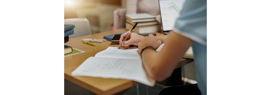 foto di mano che scrive su foglio bianco